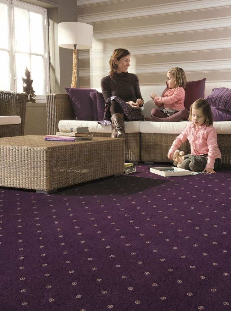 Frau zwei Mädchen auf lilafarbenen Teppichbelag mit Muster